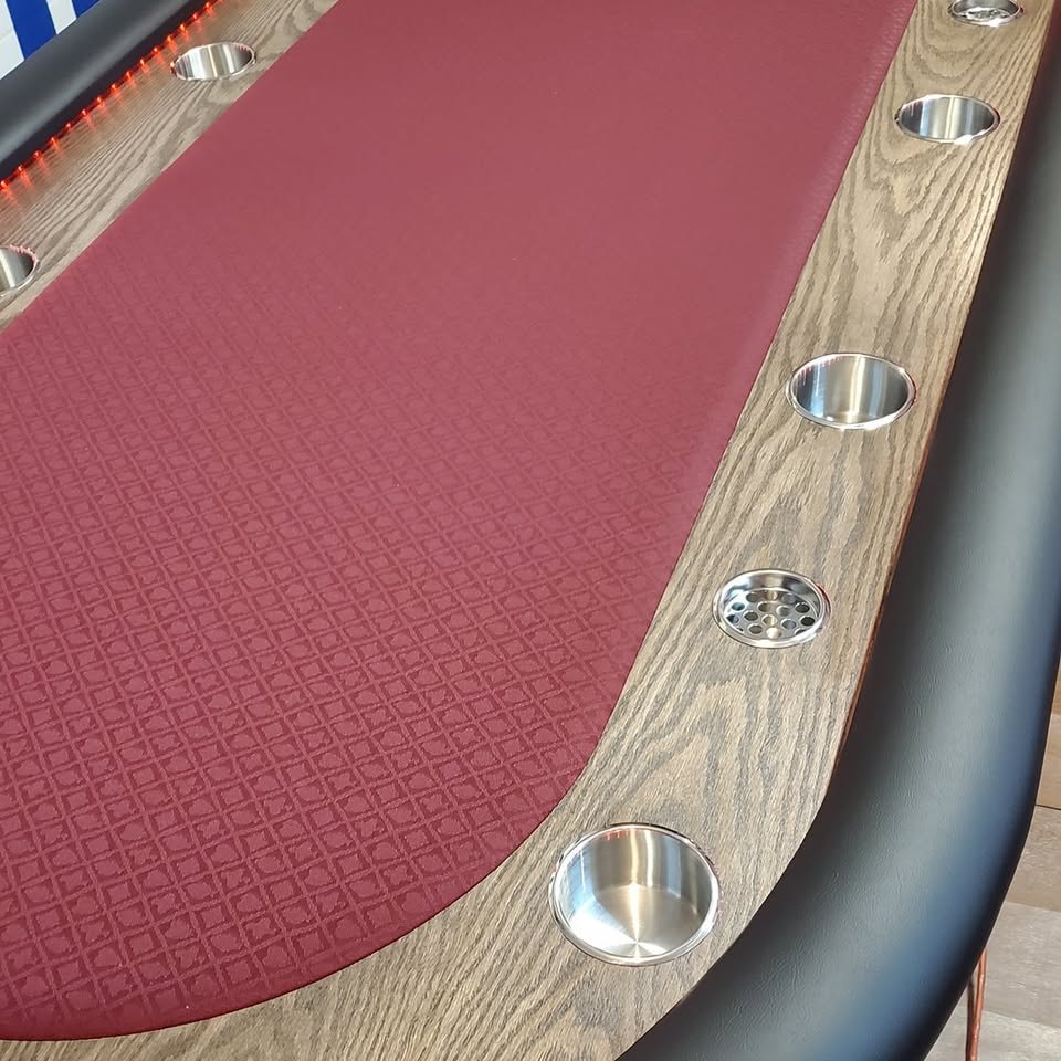 Close view of the oak rail, deep red felt and cup holders on a Platinum Poker Tables build