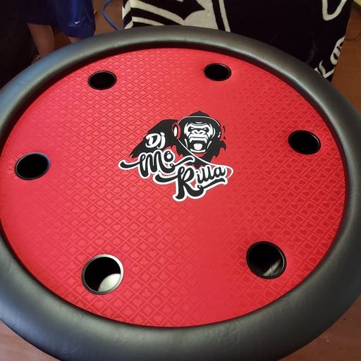Round poker table with a custom 'Me Shark' felt design